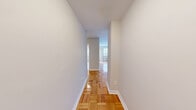 Located at 565 Avenue Rd in Toronto's desirable Avenue Road corridor, Suite 506 is a well-appointed one-bedroom, one-bathroom residence situated within a classic mid-rise brick building. The unit is laid out efficiently across a single floor, encompassing a living room, bedroom, kitchen, entrance, and bathroom.

Warm parquet flooring runs throughout the main living and bedroom areas, lending a timeless character to the interior. The living room is bright and open, featuring a large window with a radiator beneath it, allowing natural light to fill the space. A private balcony is accessible from the living area, offering leafy treetop views alongside a glimpse of the Toronto skyline — a standout feature of this suite.

The galley-style kitchen is thoughtfully equipped with white cabinetry, ample counter space, tile flooring, and stainless steel appliances including a refrigerator, electric range, dishwasher, and microwave. The bedroom is a comfortable size, featuring a sliding-door closet, built-in shelving, a window with city views, and continuity of the parquet flooring. The bathroom includes a full soaker tub finished with clean white subway tile surround and modern chrome fixtures.

The building itself presents a striking brick facade with uniform balconies and is surrounded by mature greenery, contributing to a calm and established neighbourhood ambiance.
