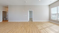 Located at 5808 Nall Ave in Mission, KS, this thoughtfully designed single-story home offers a clean, modern aesthetic throughout. The open-concept living, dining, and kitchen area serves as the heart of the home, anchored by a large granite-topped kitchen island with an integrated sink. White shaker cabinetry, a subway tile backsplash, and a full suite of stainless steel appliances — including a range, microwave, and refrigerator — complete the kitchen. Light hardwood-style flooring flows throughout the main areas, complementing the neutral wall tones and crisp white trim. The living area is bathed in natural light from multiple large windows and a glass exterior door, creating a bright and airy atmosphere. The generously sized primary bedroom features plush carpet, a ceiling fan, and a window overlooking the outdoors. The full primary bathroom offers a double-sink vanity with granite countertops, a soaking tub/shower combination, and hardwood-style flooring. A separate half bath with a pedestal sink provides added convenience for guests. The dedicated laundry room houses a full-size washer and dryer. Additional spaces include an entrance, utility room, and a closet, rounding out this well-appointed home.