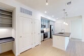Located in Houston's 77084 zip code, this single-story, 3-bedroom, 1-bathroom home offers a well-designed layout across a comfortable footprint. Light hardwood flooring flows throughout, complemented by crisp white walls and crown molding that lend a clean, modern aesthetic.

The heart of the home is an open-concept space combining the living room, dining area, and kitchen. The kitchen stands out with soft blue-gray upper cabinetry reaching the ceiling for ample storage, white lower cabinets, a dark stone countertop island with a stainless steel sink and pendant lighting above, and a full suite of stainless steel appliances including a French door refrigerator, electric range, and built-in microwave. A dedicated pantry adds extra storage convenience.

All three bedrooms feature light hardwood floors, ceiling fans, and multiple windows that invite generous natural light and neighborhood views. Each room includes its own closet, with the primary bedroom offering a walk-in closet. The full bathroom is clean and functional, located adjacent to the primary closet space.

A dedicated laundry room houses a full-size washer and dryer. The home also includes an outdoor patio, ideal for relaxing. Crown molding, recessed lighting, and consistent finishes throughout give this home a cohesive, polished character.