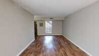 Located at 19 W Lakeshore Dr in Homewood, AL, this single-floor, 3-bedroom, 2-bathroom home offers a well-organized layout designed for comfortable everyday living. The living room makes a strong first impression with rich, dark hardwood-style flooring that extends throughout the main living areas, neutral gray walls, and a front-facing window that draws in natural light. The dining area is a standout feature, boasting a sweeping bay window arrangement with horizontal blinds that frame outdoor views, complemented by an elegant pendant light fixture overhead. The kitchen is thoughtfully designed with white cabinetry, dark speckled countertops, a double stainless steel sink, black appliances including a refrigerator and range, and a skylight that brightens the workspace. A hallway connects the bedrooms and bathrooms toward the rear of the home. The spacious primary bedroom features plush carpeting, a ceiling fan with light, and dual windows that invite natural light. Additional bedrooms are carpeted and well-sized, each with ventilation and easy hallway access. The bathrooms are clean and functional — one features wood-style flooring with a full tub-shower surround and white fixtures, while the other includes a vanity with dark countertops and overhead lighting. A closet provides added storage throughout this efficiently laid-out home.