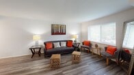 This single-floor residence offers a thoughtfully designed layout that balances comfort and functionality across its key living spaces. The living room serves as the heart of the home, featuring wood-look plank flooring, neutral walls, and a large window that invites natural light and outdoor views. The open, airy feel of this space makes it well-suited for both relaxing and entertaining.

The kitchen is outfitted with white shaker-style cabinetry, granite countertops, a tile backsplash, and a full suite of stainless steel appliances including a gas range, microwave, dishwasher, and refrigerator. A generous countertop island provides additional workspace and casual seating potential. An adjacent dining area features a sliding door with vertical blinds, allowing natural light to filter through.

The two bedrooms are carpeted and offer a calm, restful atmosphere. Each room accommodates full-sized furniture comfortably and includes windows for natural ventilation and light.

Two bathrooms serve the residence: one features a granite vanity and a glass-enclosed walk-in shower with tile flooring, while the second includes a granite vanity, white cabinetry, and a full tub-shower combination. Both bathrooms are finished with coordinating tile and tasteful fixtures, contributing to the overall polished character of the space.