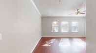 Located at 8383 El Mundo St in Houston, TX, this well-appointed one-bedroom, one-bathroom residence offers a thoughtfully designed single-floor layout. The open living room makes a strong first impression with rich hardwood flooring, crown molding, a ceiling fan with light fixture, and a textured ceiling. Multiple windows dressed with blinds flood the space with natural light, creating a bright and welcoming atmosphere.

The kitchen is a standout feature, showcasing deep cherry-toned cabinetry, granite countertops, a stone tile backsplash, and a full suite of stainless steel appliances including a range, over-the-range microwave, and French door refrigerator. A breakfast bar provides a convenient transition between the kitchen and living area, and tile flooring completes the space.

The bedroom offers plush wall-to-wall carpeting and a generous walk-in closet outfitted with multi-tier wire shelving systems, providing ample organization and storage. The full bathroom features tile flooring, a soaking tub with a tiled surround with decorative accent border, and rich cabinetry matching the kitchen's design. A hallway connects the rooms, completing this cohesive and functional floor plan.