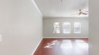 Located at 8383 El Mundo St in Houston, TX, this well-appointed one-bedroom, one-bathroom residence offers a thoughtfully designed single-floor layout. The open living room makes a strong first impression with rich hardwood flooring, crown molding, a ceiling fan with light fixture, and a textured ceiling. Multiple windows dressed with blinds flood the space with natural light, creating a bright and welcoming atmosphere.

The kitchen is a standout feature, showcasing deep cherry-toned cabinetry, granite countertops, a stone tile backsplash, and a full suite of stainless steel appliances including a range, over-the-range microwave, and French door refrigerator. A breakfast bar provides a convenient transition between the kitchen and living area, and tile flooring completes the space.

The bedroom offers plush wall-to-wall carpeting and a generous walk-in closet outfitted with multi-tier wire shelving systems, providing ample organization and storage. The full bathroom features tile flooring, a soaking tub with a tiled surround with decorative accent border, and rich cabinetry matching the kitchen's design. A hallway connects the rooms, completing this cohesive and functional floor plan.