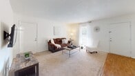This single-story residence offers a thoughtfully arranged floor plan with a cohesive, neutral aesthetic maintained across all rooms. The living room is a comfortable, carpeted space that receives natural light through a window fitted with sheer curtains, creating a bright and welcoming atmosphere. Adjacent to the living area, a dedicated dining space features wood-look flooring and a window that allows additional natural light to filter in.

The galley-style kitchen is efficiently designed with white cabinetry, granite-patterned countertops, wood-look flooring, and white appliances, including a refrigerator, electric range, and dishwasher, maximizing functionality within the available space.

The primary bedroom is carpeted and features a ceiling fan with a light fixture, a window with sheer curtains, and ample natural light. A second bedroom also includes carpet, a ceiling fan, a window, and a built-in closet with organizational shelving. Both bathrooms mirror the kitchen's design language, featuring white cabinetry, granite-patterned countertops, and wood-look flooring. One bathroom includes a shower-tub combination, while the other functions as a half bath. The overall design is clean and consistent throughout.