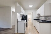 Located at 9450 128 St in Surrey, BC, this 2-bedroom, 1-bathroom unit offers a well-organized, single-floor layout designed for comfortable everyday living. The interior features updated light-toned laminate flooring throughout, crisp white walls, and baseboard heating, creating a clean and cohesive aesthetic.

The galley-style kitchen is outfitted with white cabinetry, dark countertops, a subway tile backsplash, and a full suite of appliances including a white electric range and black refrigerator. The kitchen connects directly to a dedicated dining area and flows into two living spaces, offering flexibility for lounging and entertaining. A sliding glass door in the main living area opens onto a private balcony, allowing natural light to fill the room.

Both bedrooms are well-proportioned with large windows that bring in outdoor views and natural light. The primary bedroom includes a dedicated closet, and the unit benefits from four closets in total, providing generous storage throughout. A bright hallway connects the main living areas to the bedrooms and bathroom.

The bathroom features warm-toned tile wainscoting, a mirrored vanity, and light flooring, creating a tidy and functional space. Overall, this unit presents a practical and neatly finished interior well-suited to a variety of living arrangements.
