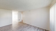 Located at 8081 Holland Dr in Huntington Beach, CA, this single-story, 3-bedroom, 1-bathroom home offers a practical and well-organized layout. Throughout the space, light wood-look flooring provides a clean, cohesive aesthetic, complemented by neutral white walls and textured popcorn ceilings.

The living area is an open, welcoming space filled with natural light through a large window fitted with vertical blinds, offering views of surrounding greenery. The kitchen is efficiently designed with rich granite-style countertops, cream cabinetry, ample upper storage, and full appliance provisions including a refrigerator.

The primary bedroom is generously sized, featuring a mirrored sliding-door closet with gold-tone framing and a large window that invites natural light. The two additional bedrooms are well-proportioned, each with closet access and neutral finishes. One bedroom features a window with outdoor views of lush vegetation, adding a pleasant natural element.

The bathroom is appointed with granite-style countertops matching the kitchen, a framed mirror, wood-look flooring, and a shower/tub combination. The overall ambiance of the home is bright, clean, and move-in ready, making it a functional residence in a convenient Southern California location.
