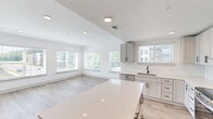 Located at 15120 Idlewild Road in Matthews, NC, this well-appointed 3-bedroom, 4-bathroom unit offers a thoughtfully designed open-concept layout across a single floor. The combined kitchen and living area serves as the heart of the home, featuring light wood-look flooring, recessed lighting, and large windows fitted with blinds that flood the space with natural light. The modern kitchen is equipped with gray shaker-style cabinetry, white quartz countertops, a subway tile backsplash, stainless steel appliances, and a central island — ideal for both everyday cooking and entertaining. The generously sized primary bedroom includes a tray ceiling with a ceiling fan, plush carpeting, a walk-in closet with wire shelving, and an en-suite bathroom. The additional bedrooms are well-proportioned, also carpeted, and served by their own bathrooms. All four bathrooms maintain a consistent, contemporary aesthetic with gray vanity cabinets, white quartz countertops, large framed mirrors, and matte black fixtures. Two dedicated closets provide ample storage throughout. A private balcony extends the living space outdoors, offering open views of the surrounding community. The unit presents a clean, neutral palette throughout, creating a bright and welcoming atmosphere.