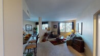 Located at 7149 Navajo Road in San Diego, this well-appointed single-floor residence offers a comfortable and functional layout designed for everyday living. The open-concept living and dining area is generously sized, featuring plush carpeting, large windows that invite abundant natural light, and a seamless flow between spaces. A breakfast bar with bar seating connects the living area to the kitchen, which is outfitted with white cabinetry, dark countertops, a gas range, dishwasher, and ample storage. The dining area is positioned near a sliding glass door that opens to a private balcony, offering pleasant outdoor views and additional seating space. Two well-sized bedrooms provide comfortable retreats, each with carpeted floors and windows that bring in natural light. The unit includes two full bathrooms, each featuring a tub-shower combination with tile surround and vanity with storage. Track lighting accents the dining and kitchen areas, while neutral wall tones throughout lend a clean, cohesive feel to the entire space. The open layout and thoughtful design make this residence a practical and inviting home in the heart of San Diego.