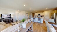 Located at 5076 Branch Point Dr in Valdosta, Georgia, this single-story home presents a cohesive, light-filled interior defined by warm neutral tones and durable wood-look flooring throughout. The layout flows naturally from a welcoming entryway corridor flanked by interior doors and built-in storage, leading into the heart of the home.

The open-concept living and dining area is a central highlight, where natural light pours in through multiple windows and French doors that overlook a fenced outdoor area. The living space accommodates generous seating, while the adjacent dining area features room for a full dining table set beneath a softly lit, art-adorned wall.

The kitchen is well-appointed with white shaker-style cabinetry, granite countertops, stainless steel appliances, and an island with bar seating—seamlessly connected to the main living area. Recessed lighting adds a clean, modern touch overhead.

Bedrooms are comfortably sized with ample natural light and neutral walls. A spacious walk-in closet with wire shelving provides excellent storage. The bathroom includes a full tub-shower combination with clean white surround panels. A dedicated laundry room with full-size washer and dryer hookups adds everyday convenience.