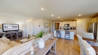 Located at 5076 Branch Point Dr in Valdosta, Georgia, this single-story home presents a cohesive, light-filled interior defined by warm neutral tones and durable wood-look flooring throughout. The layout flows naturally from a welcoming entryway corridor flanked by interior doors and built-in storage, leading into the heart of the home.

The open-concept living and dining area is a central highlight, where natural light pours in through multiple windows and French doors that overlook a fenced outdoor area. The living space accommodates generous seating, while the adjacent dining area features room for a full dining table set beneath a softly lit, art-adorned wall.

The kitchen is well-appointed with white shaker-style cabinetry, granite countertops, stainless steel appliances, and an island with bar seating—seamlessly connected to the main living area. Recessed lighting adds a clean, modern touch overhead.

Bedrooms are comfortably sized with ample natural light and neutral walls. A spacious walk-in closet with wire shelving provides excellent storage. The bathroom includes a full tub-shower combination with clean white surround panels. A dedicated laundry room with full-size washer and dryer hookups adds everyday convenience.