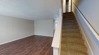 This two-story South Carolina residence offers a practical and well-organized layout across both levels. The main floor features a open living area finished with durable wood-look flooring and neutral-toned walls, providing a clean, versatile backdrop for furnishing. A carpeted staircase connects the two floors, adding a comfortable transition between living spaces.

The kitchen is equipped with warm-toned oak cabinetry offering generous storage, light-colored countertops, a double-basin sink, and white appliances including a dishwasher, range, and refrigerator. An adjacent dining or entry area benefits from a window that allows natural light to filter in, along with direct exterior door access.

The bedrooms are carpeted and designed with simplicity in mind, featuring neutral walls and textured ceilings. Several rooms include closets with built-in hanging rods for storage convenience. One bedroom features a notably wide window that brings in ample natural light.

The bathroom is fitted with a vanity featuring wood-toned cabinetry, a light-colored countertop, a large mirror, and a shower-tub combination with a decorative curtain. Throughout the home, consistent use of neutral colors and practical finishes creates a cohesive, move-in-ready environment.