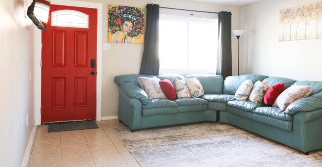 Acogedor salón. Sofá esquinero de piel auténtica, toques de rojo, comodidad por doquier. - 8612 Echo St