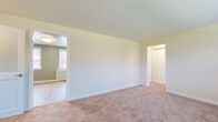 Located at 1 Garden Terrace in North Arlington, NJ, this single-floor unit offers a well-organized layout with a comfortable, functional design throughout. The living and bedroom areas feature neutral-toned wall-to-wall carpeting and light-colored walls that create a clean, airy feel. Multiple rooms are equipped with wall-mounted air conditioning units and classic radiator covers beneath windows fitted with slatted blinds, ensuring year-round comfort. Several rooms include closet access, and one bedroom features a ceiling fan for additional ventilation. The kitchen stands out with rich, dark-stained cabinetry, granite-style countertops, and black appliances including a gas range, built-in microwave, dishwasher, and stainless steel refrigerator. Light hardwood-style flooring and sage-green walls give the kitchen and adjoining dining area a warm, inviting character, with dual windows allowing ample natural light to fill the space. The bathroom is tastefully finished with floor-to-ceiling tile work, a decorative mosaic tile border, a tub and shower combination, a white vanity with a stone-top sink, and a window that brings in natural light. Throughout the unit, clean white trim and panel-style doors contribute to a cohesive and well-maintained aesthetic.
