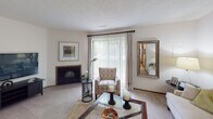 Located at 3358 Alden Pond Ln in Eagan, Minnesota, this two-story home offers a well-organized layout across two levels. The living room serves as a welcoming centerpiece, featuring a wood-trimmed fireplace, plush carpeting, and a sliding glass door that fills the space with natural light and provides outdoor access. Adjacent to the living area, the dining space accommodates a round wooden table and chairs set beneath a window, with warm hardwood-style flooring completing the look. The kitchen is efficiently designed with warm oak cabinetry, white appliances, ample counter space, and hardwood-style flooring, providing a functional and classic cooking environment. Upstairs, the primary bedroom is generously proportioned with a folding-door closet, natural light from a large window, and direct access to a well-appointed ensuite bathroom. The primary bath features a soaking tub, a separate glass-enclosed shower stall, a dual-sink vanity, and tile flooring. A second bedroom offers comfortable carpeting and bright windows with blinds. An additional bathroom with a single vanity and clean finishes serves the remaining rooms. Throughout the home, textured ceilings, warm neutral tones, and wood-trimmed doorways contribute to a cohesive and comfortable aesthetic.