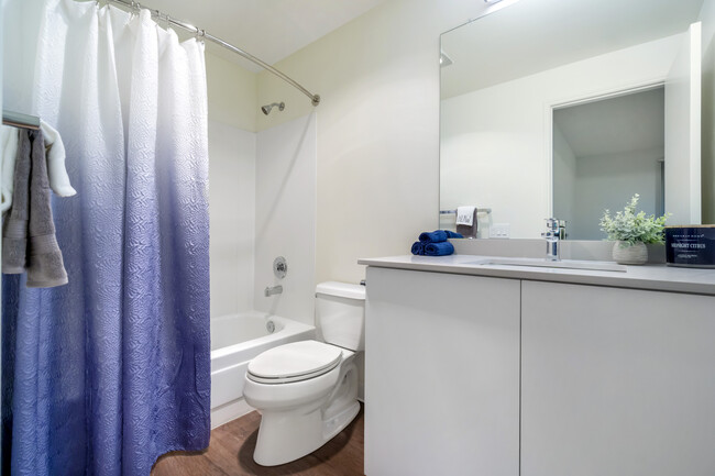 Renovated III bathroom with white cabinetry, grey quartz countertops, and hard surface flooring - Archstone Redmond Lakeview