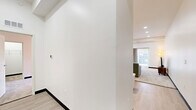 Located at 1951 E Sternberg Rd in Muskegon, Michigan, this single-floor, 2-bedroom, 1-bathroom residence offers a thoughtfully designed layout with modern finishes throughout. The open-concept kitchen and living area serves as the heart of the home, featuring light hardwood-style flooring, gray shaker-style cabinetry, white quartz countertops, stainless steel appliances, and a peninsula with bar seating — ideal for casual dining and entertaining. The spacious living room is carpeted and bathed in natural light through a large sliding glass door framed by neutral drape panels, creating a bright and welcoming atmosphere. The generous primary bedroom features a tray ceiling, plush carpeting, a sliding glass door with outdoor views, and a dedicated closet. The second bedroom is equally comfortable, with soft carpet, clean white walls, and easy hallway access. The full bathroom is finished with large-format marble-look tile flooring, a combined tub and shower, and a gray vanity with light countertops, maintaining the home's cohesive contemporary aesthetic. A hallway connects all rooms efficiently, and the overall palette of whites, grays, and warm neutrals lends the space a clean, modern, and inviting character throughout.