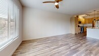 This well-appointed one-bedroom, one-bathroom unit at 141 36th St in Los Alamos, NM offers a thoughtfully designed single-floor layout with modern finishes throughout. The open-concept living and kitchen area serves as the heart of the unit, featuring wood-look plank flooring, a ceiling fan with light fixture, and a large window that invites natural light and outdoor views of surrounding greenery.

The kitchen is a standout feature, showcasing light wood cabinetry, granite countertops, a central island with a built-in sink and pendant lighting overhead, and a full suite of stainless steel appliances including a gas range, microwave, and refrigerator. Track lighting and a tile backsplash complete the contemporary aesthetic.

A hallway connects the main living area to the private bedroom, which is generously proportioned and carpeted for comfort. The bedroom includes a ceiling fan, a closet, and a window with outdoor views.

The bathroom is finished to a high standard, featuring a dual-sink vanity with granite countertops, light wood cabinetry, and large wall mirrors illuminated by modern sconce lighting. Wood-look tile flooring ties the space together cohesively, maintaining a clean, contemporary feel throughout the unit.