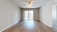 Located at 3305 Grant Cove Circle in Cape Coral, Florida, this thoughtfully designed 3-bedroom, 2-bathroom residence offers comfortable single-floor living with a clean, modern aesthetic throughout. The open-concept living, dining, and kitchen area serves as the heart of the home, where wood-look flooring, a ceiling fan, and sliding glass doors lead to a private patio, filling the space with natural light and an airy feel. The kitchen is a standout, featuring rich dark cabinetry that reaches the ceiling, gleaming granite countertops, a large island with a sink, pendant lighting, and black appliances — a functional and stylish space for cooking and entertaining. Both bathrooms continue the granite and dark cabinetry motif; the primary bath offers a double-sink vanity and a walk-in glass shower, while the second bath features a similarly refined finish. The three bedrooms are carpeted for comfort, each equipped with a ceiling fan and natural light from well-placed windows. The primary bedroom is generously sized, and the home boasts an impressive seven closets throughout, providing exceptional storage. A connecting hallway ties the layout together seamlessly, making this residence as practical as it is inviting.