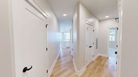Located at 1800 Silas Deane Hwy in Rocky Hill, CT, this thoughtfully designed single-floor residence offers three bedrooms, two bathrooms, and a well-organized layout that maximizes both comfort and functionality. Light hardwood flooring flows throughout the main living areas and hallways, while neutral warm tones create a clean, modern aesthetic.

The open-concept kitchen and living area serves as the heart of the home, featuring a large central island with a undermount sink and pendant lighting, white shaker-style cabinetry with matte black hardware, quartz countertops, a subway tile backsplash, and a full suite of stainless steel appliances. A bright hallway connects the living spaces to the bedrooms, lined with five closets for generous storage.

The spacious primary bedroom is bathed in natural light from multiple windows and showcases light hardwood flooring. The two additional bedrooms offer plush carpeting and dedicated windows with outdoor views. Both bathrooms are finished with white cabinetry, quartz countertops, and matte black fixtures; one features a double-sink vanity with lighted mirrors, while the other includes a walk-in shower. A dedicated laundry area adds everyday convenience to this well-appointed home.