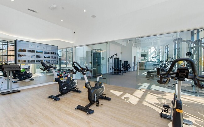 Fitness Studio Featuring Cardio Bikes, Virtual Training, and Mirrored Wall - NoDa Flats