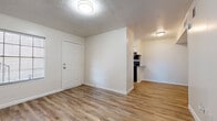 This single-story unit at 13941 Alderson St in Houston, TX is designed with a practical, straightforward layout that maximizes functionality throughout. The interior is finished with light-toned vinyl plank flooring across the main living areas, lending a clean, cohesive look that is both durable and easy to maintain. Textured ceilings are present throughout, adding a classic touch consistent with the home's construction era.

The living area offers an open, neutral canvas with crisp white walls, multiple electrical outlets, and HVAC vents ensuring year-round comfort. The space flows naturally toward the kitchen, which features white cabinetry, gray laminate countertops, a double-basin sink beneath a window that allows natural light in, and black stainless appliances including a refrigerator, electric range with overhead ventilation, and a dishwasher. A peninsula counter provides a casual dining or prep option.

The bedroom is carpeted and generously sized, featuring a ceiling fan with integrated lighting, a window with blinds, and two closets, one of which offers open shelving for organized storage. The bathroom includes vinyl plank flooring, a full-size tub and shower combo, and a toilet, keeping the space functional and tidy.