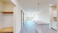 Located at 70 Cambrian Way in Burlington, Vermont, this two-bedroom, one-bathroom residence offers a thoughtfully designed layout with clean, modern finishes throughout. The open-concept kitchen and living area serves as the heart of the home, featuring light hardwood-style flooring, crisp white cabinetry, granite-look countertops, a central island with pendant lighting, and a full suite of stainless steel appliances. A sliding barn door adds a stylish architectural touch, connecting the living space to the bedrooms with ease.

The primary bedroom is generously sized, bathed in natural light through a bank of large windows that frame stunning views of Lake Champlain and the surrounding mountains — a defining feature of this elevated Burlington location. The second bedroom offers carpeted flooring, a wall-mounted mini-split system for climate control, and its own window with scenic views.

The full bathroom is finished with light tile flooring, a white vanity with brushed nickel hardware, and a walk-in shower. A dedicated hallway and closet provide practical storage. Throughout the residence, neutral tones, abundant natural light, and quality finishes create a bright, welcoming ambiance ideal for comfortable everyday living.