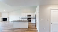 Located at 333 White Cedar Pky in Kimberly, WI, this well-appointed one-bedroom, one-bathroom home offers a clean, modern aesthetic throughout its thoughtfully designed single-floor layout. Light-toned hardwood-style flooring flows seamlessly across every room, creating a cohesive and bright atmosphere.

The open-concept kitchen and living area serves as the heart of the home. The kitchen is outfitted with crisp white shaker-style cabinetry extending to the ceiling, granite countertops, a center island with a built-in sink, and a full suite of stainless steel appliances including a French door refrigerator, electric range, and over-the-range microwave. The adjacent living room is anchored by a fireplace and a wall of sliding glass doors that flood the space with natural light and provide direct access to an outdoor green area. A baseboard heating system runs along the living room wall for efficient climate control.

The spacious primary bedroom features a ceiling fan, a window with outdoor views, and a dedicated closet. A wall-mounted ductless mini-split unit in a secondary area ensures additional climate flexibility. The bathroom mirrors the kitchen's refined style with white cabinetry, granite countertops, and a baseboard heater. The overall ambiance is clean, contemporary, and move-in ready.