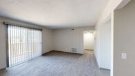 Located at 322 W 65th St in Davenport, Iowa, this two-bedroom, one-bathroom residence offers a practical and comfortable single-floor layout. The living room is generously sized, featuring soft carpeting, neutral gray walls, and a full-width sliding glass door fitted with vertical blinds that invites natural light and provides outdoor access. A dedicated entryway with a solid white door connects seamlessly to the main living area.

The kitchen is well-appointed with warm oak cabinetry, ample upper and lower storage, light countertops, a double-basin sink, and wood-look vinyl flooring. White appliances, including a refrigerator and electric range, complete the functional cooking space.

Both bedrooms are carpeted and finished in neutral tones, creating a calm and restful atmosphere. The primary bedroom offers a spacious feel with a large open closet featuring a double hanging rod, along with a window that brings in natural light. The second bedroom is similarly comfortable with good proportions.

The full bathroom includes a tub-shower combination, a vanity with dark cabinetry, a toilet, and wood-look tile flooring, offering a clean and efficient design. A hallway connects the bedrooms and bathroom, ensuring a logical and easy-to-navigate floor plan throughout the home.
