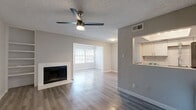 Located at 6011 Oakland Hills Dr in Fort Worth, TX, this single-story, one-bedroom, one-bathroom home offers a well-designed layout across a comfortable footprint. The open-concept living and dining area serves as the heart of the home, anchored by a white tile-surround wood-burning fireplace and complemented by built-in shelving on the adjacent wall. A ceiling fan with light kit adds both style and function, while light-toned laminate flooring runs throughout, creating a cohesive, modern aesthetic. Natural light pours in through large windows that overlook the dining area, brightening the entire space.

The kitchen is thoughtfully designed with white shaker-style cabinetry, gray countertops, a classic white subway tile backsplash, and a full suite of stainless steel appliances, including a refrigerator, range, and over-the-range microwave. A pass-through window connects the kitchen to the living area, enhancing the open feel.

The bedroom is a quiet, well-proportioned retreat featuring a ceiling fan, a window with blinds, and direct access to two closets — one of which is a spacious walk-in. The bathroom includes a full tub/shower combination with white tile surround. Textured ceilings are present throughout, adding a classic residential character to the home.
