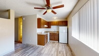 Located at 2430 N Dodge Blvd in Tucson, Arizona, this efficiently designed one-bedroom, one-bathroom unit offers a practical and comfortable layout across a single floor. The living room serves as the main gathering space, featuring wood-look vinyl flooring, a ceiling fan with light fixture, a wall-mounted A/C unit, and a large window with vertical blinds that allows natural light to brighten the room. The kitchen is equipped with warm-toned wood cabinetry, a coil-burner electric range, a stainless steel sink, ample upper and lower cabinet storage, a range hood, and a full-size refrigerator — all set on matching wood-look flooring beneath a ceiling fan. The bedroom offers a carpeted floor and a textured ceiling, providing a quiet and comfortable retreat. A dedicated closet offers convenient storage. The bathroom features wood-look tile flooring, an open vanity with a single sink, a medicine cabinet mirror, and a separate toilet and shower/tub area. Neutral wall tones and textured ceilings are consistent throughout, giving the unit a cohesive, understated aesthetic well-suited to Tucson's sunny climate.