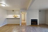 Located at 3200 Quarry Dr in Lafayette, Indiana, this single-floor, one-bedroom, one-bathroom home offers a well-organized layout that makes efficient use of its space. The living room serves as the heart of the home, highlighted by a classic wood-burning fireplace with a white surround and hardwood-style flooring that extends throughout the main living areas. Sliding glass doors provide direct access to a private patio, bringing in natural light and a seamless indoor-outdoor connection. Adjacent to the living room, the dining area opens to a pass-through kitchen equipped with white cabinetry, a gas range, a full-size refrigerator, and a countertop bar that doubles as a casual dining surface. A hallway connects the main living spaces to the private quarters, offering ample storage with multiple closets along the way. The bedroom features soft carpeting, a large window with natural light, and a wide bi-fold closet providing generous storage. The bathroom includes a vanity with wood cabinetry, an over-mirror medicine cabinet, and a tub-shower combination. Neutral tones and clean finishes throughout give the home a bright, move-in ready feel suited for comfortable everyday living.