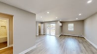 Located at 21-8 Civic Center Dr in East Brunswick, NJ, this thoughtfully renovated single-floor unit offers a clean, contemporary aesthetic throughout. Light-toned luxury vinyl plank flooring runs seamlessly across all living areas, complementing the neutral warm-gray wall palette and crisp white baseboards.

The open living area is bright and spacious, with recessed lighting overhead and large sliding glass doors that lead to a private balcony, flooding the space with natural light and offering pleasant outdoor views. An additional window further enhances the airy feel of the room.

The kitchen is a standout feature, outfitted with rich dark-toned shaker cabinetry, white quartz countertops, and a classic subway tile backsplash. A full suite of stainless steel appliances — including a gas range, over-the-range microwave, dishwasher, and full-size refrigerator — make it both functional and stylish.

The bedrooms are generously proportioned, each with natural light and wall-unit air conditioning. Additional rooms provide flexible living space with recessed lighting and baseboard heating.

The bathroom is elegantly finished with floor-to-ceiling marble-look tile surrounding a soaking tub and shower combination, paired with a sleek vanity and mirrored medicine cabinet. The overall design is cohesive, modern, and move-in ready.