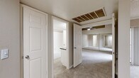 Located at 4909 W Joshua Blvd in Chandler, AZ, this one-bedroom, one-bathroom residence offers a well-organized single-level layout with a comfortable and functional living environment. The open-concept living, dining, and kitchen area forms the heart of the home, featuring wood-look flooring, crown molding, and a textured ceiling. Large sliding glass doors flood the living room with natural light and open directly onto a private balcony, while an additional window enhances the bright, airy feel of the space. The kitchen is thoughtfully designed with white shaker-style cabinetry, dark granite countertops, stainless steel appliances including a refrigerator, range, and microwave, recessed lighting, and a peninsula that provides a natural divide between the kitchen and living areas. The spacious bedroom features plush carpet, a ceiling fan with a decorative wood-accented tray detail, and floor-to-ceiling mirrored closet doors. The bathroom offers a granite-topped vanity with white cabinetry, a large mirror, and a full soaking tub. Additional highlights include a hallway with multiple closets for generous storage, a dedicated laundry area, and a utility room, rounding out this well-appointed Chandler residence.