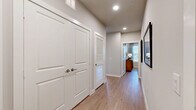 This thoughtfully designed 2-bedroom, 2-bathroom residence offers a comfortable and modern living experience across a single floor. Light-toned hardwood flooring flows seamlessly throughout, lending warmth and continuity to every room.

The open-concept kitchen is a standout feature, showcasing white shaker cabinetry, a classic subway tile backsplash, stainless steel appliances, and a large quartz-topped island with bar seating — ideal for both everyday meals and entertaining. The adjacent living room is bright and welcoming, with a bank of windows that fill the space with natural light and offer views of the surrounding outdoors.

A well-lit hallway connects the bedrooms, each offering ceiling fans, generous windows, and a calm, neutral palette. The primary bedroom is notably spacious and includes direct access to its own bathroom. Both bathrooms are finished with white vanities, clean tile work, and tub-shower combinations.

The residence includes five closets throughout, providing exceptional storage options, including a large walk-in closet with multi-tiered shelving and hanging rods. A dedicated laundry area adds everyday convenience. Recessed lighting and a consistent soft gray color scheme create a cohesive, modern ambiance throughout the entire home.