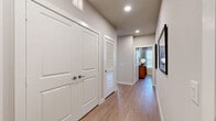 This thoughtfully designed 2-bedroom, 2-bathroom residence offers a comfortable and modern living experience across a single floor. Light-toned hardwood flooring flows seamlessly throughout, lending warmth and continuity to every room.

The open-concept kitchen is a standout feature, showcasing white shaker cabinetry, a classic subway tile backsplash, stainless steel appliances, and a large quartz-topped island with bar seating — ideal for both everyday meals and entertaining. The adjacent living room is bright and welcoming, with a bank of windows that fill the space with natural light and offer views of the surrounding outdoors.

A well-lit hallway connects the bedrooms, each offering ceiling fans, generous windows, and a calm, neutral palette. The primary bedroom is notably spacious and includes direct access to its own bathroom. Both bathrooms are finished with white vanities, clean tile work, and tub-shower combinations.

The residence includes five closets throughout, providing exceptional storage options, including a large walk-in closet with multi-tiered shelving and hanging rods. A dedicated laundry area adds everyday convenience. Recessed lighting and a consistent soft gray color scheme create a cohesive, modern ambiance throughout the entire home.