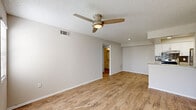 This single-floor, 2-bedroom, 2-bathroom unit offers a practical and well-finished living environment across a compact but efficiently arranged floor plan. The open-concept living and kitchen area serves as the central hub of the unit, with warm wood-look laminate flooring, neutral-toned walls, and a ceiling fan with integrated lighting. Windows allow natural light to brighten the space, creating an airy atmosphere.

The kitchen is a standout feature, equipped with white shaker-style cabinetry, granite countertops, a tile backsplash, stainless steel appliances including a refrigerator and electric range, and an undermount sink. A skylight above adds additional natural illumination, while a peninsula counter connects the kitchen to the living area.

Both bedrooms are comfortably sized, featuring plush carpeting, ceiling fans, and windows that provide natural light. Each bedroom includes closet access and connects to the hallway.

The two bathrooms offer granite-topped vanities with undermount sinks and framed mirrors. One bathroom features a tub/shower combination, while the other includes a walk-in shower stall, both finished in a clean, neutral palette. A hallway connects all rooms, completing the functional layout.