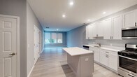 Located at 99 N White Horse Pike in Somerdale, NJ, this thoughtfully designed one-bedroom, one-bathroom residence offers a clean, modern aesthetic with functional living spaces across a single floor. Light gray walls, recessed lighting, and light-toned luxury vinyl plank flooring run throughout, creating a cohesive and contemporary atmosphere.

The open-concept kitchen and living area serves as the heart of the home. The kitchen is well-appointed with white shaker-style cabinetry, crisp white countertops, a full suite of stainless steel appliances including a gas range, built-in microwave, dishwasher, and refrigerator, as well as a central island that offers additional prep and dining space. The living area flows seamlessly from the kitchen and receives natural light through large windows with roller shades, with direct access to a private balcony overlooking the surrounding neighborhood.

The bedroom is generously sized, featuring large windows that bring in ample natural light and outdoor views. Two closets provide practical storage. The full bathroom includes a shower-tub combination, a vanity, and consistent vinyl flooring. A dedicated laundry area adds everyday convenience. The unit also benefits from a smart thermostat and modern hardware details throughout.
