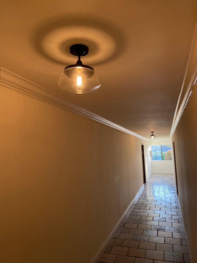 Exterior hallway, freshly painted, and beautiful pendant lighting (art coming soon) - 1540 Brockton Ave