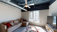 Located at 315 W Pine St in Mount Airy, NC, this single-floor urban loft-style unit blends industrial character with modern comfort. The living area makes a strong architectural statement with its dramatic exposed ceiling — featuring dark steel beams, metal decking, and large silver ductwork — complemented by a ceiling fan and a large window that fills the room with natural light. The tiled accent wall adds texture, while the open layout provides a comfortable and functional living space.

The galley-style kitchen is well-appointed with dark espresso cabinetry, granite countertops, a stainless steel refrigerator, built-in microwave, and dishwasher — offering a polished, efficient workspace. The bedroom continues the loft aesthetic with exposed ductwork overhead, a ceiling fan, and a frosted glass panel that diffuses soft, ambient light. Ample closet space and room for full furniture sets make it a practical retreat.

The bathroom features a full tub-shower combination, granite vanity top, and clean neutral finishes throughout. A dedicated in-unit laundry closet with a full-size washer and dryer adds significant everyday convenience. Throughout the unit, the interplay of industrial design elements and modern finishes creates a distinctive, urban atmosphere in the heart of Mount Airy.