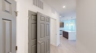 Located at Friends Crossing in Huntsville, Alabama, this single-story, three-bedroom, two-bathroom home offers a well-designed layout with contemporary finishes throughout. The kitchen is a standout feature, boasting dark wood cabinetry, white quartz countertops, a subway tile backsplash, stainless steel appliances — including a refrigerator, range, microwave, and dishwasher — and a central island illuminated by stylish pendant lighting. Light wood-look flooring runs through the main living areas, giving the space a clean, cohesive feel. The primary bedroom is a comfortable retreat with a ceiling fan, a large window that invites natural light, and direct access to a walk-in closet with built-in shelving and hanging rods. The en-suite primary bathroom features a double-sink vanity with dark wood cabinetry, white countertops, a glass-enclosed walk-in shower, and light wood-look flooring. The secondary bathroom includes a tub-shower combination and a single-sink vanity. Additional bedrooms are carpeted and feature windows with outdoor views. A dedicated laundry room houses a full-size washer and dryer. Two closets provide generous storage throughout the home, completing this functional and modern living space.
