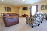 Located at 3824 Maplefield Dr in Chesapeake, Virginia, this single-floor space is thoughtfully designed to serve as a functional and comfortable communal facility. The entryway greets visitors with large tile flooring, a bright window with blinds, and a clearly marked access door, establishing a clean and organized first impression.

The main living and lounge area is spacious and open, featuring plush carpeting and warm neutral wall tones. It is furnished with a leather sectional sofa and accent chairs, creating a comfortable setting for relaxation or social gatherings. A wall-mounted flat-screen television adds an entertainment focal point, complemented by decorative accents including film reel décor and framed artwork.

An adjoining area serves as a dedicated workspace, equipped with multiple computer workstations, desk chairs, and ample desk space — ideal for productivity and shared use. Natural light filters in through window treatments, enhancing the welcoming ambiance throughout.

The kitchenette is well-appointed with warm honey-toned cabinetry, granite-style countertops, a stainless steel under-counter refrigerator, a microwave, and a utility sink. Tile flooring and decorative wall art give this area a polished, functional feel. Additional storage is provided by a set of double closet doors nearby. Together, these areas offer a versatile, well-maintained space suited for community use.