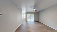 This single-floor residence offers a thoughtfully designed layout encompassing three bedrooms, four bathrooms, and a generous living and dining area. The open living room is finished with rich wood-look flooring, neutral gray walls, and a ceiling fan with light fixture, and features a sliding glass door that invites natural light while providing direct outdoor access. The adjoining dining area continues the same flooring and benefits from a trio of large windows fitted with white blinds, filling the space with abundant daylight. The kitchen is well-equipped, showcasing white cabinetry, granite countertops, a gray subway tile backsplash, a double stainless steel sink, and stainless steel appliances. Each of the three bedrooms is fitted with a ceiling fan, neutral carpet flooring, and windows with blinds, offering a comfortable and functional retreat. The primary bedroom includes its own dedicated closet with built-in shelving and hanging rods. Four closets in total provide excellent storage capacity throughout the residence. The four bathrooms include tiled tub-shower combinations, offering practical, clean-finished spaces. A connecting hallway ties the layout together efficiently, creating a cohesive and livable floor plan.