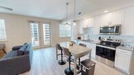 This 850 square foot apartment offers a perfect blend of comfort and coastal living. The open-concept design seamlessly integrates the living room, dining area, and kitchen, creating a spacious feel. The living room boasts a sleek electric fireplace and large windows that flood the space with natural light. The modern kitchen features white cabinetry, stainless steel appliances, and a granite countertop island that doubles as a dining area.

Both bedrooms are well-appointed, with the primary bedroom measuring 130 square feet. The bathrooms showcase contemporary design with marble-look tiled showers and granite vanity tops. Ample closet space is provided throughout the apartment.

A standout feature is the balcony, offering breathtaking views of the beach and ocean. Inside, ceiling fans and large windows ensure good air circulation and natural lighting. The light wood-look flooring throughout adds warmth and complements the overall modern aesthetic.

This apartment combines functionality with style, making it an ideal seaside retreat or permanent residence for those seeking a contemporary coastal lifestyle.