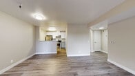 Located at 896 Davis St in San Leandro, California, this single-floor residence offers a thoughtfully designed open-concept layout with contemporary finishes throughout. The living area is expansive and bright, featuring warm wood-tone laminate flooring and neutral wall tones that create a welcoming atmosphere. Large sliding glass doors open to a private outdoor patio, while an adjacent window fills the space with natural light and views of the surrounding greenery.

The kitchen is well-appointed with white upper cabinetry, two-tone gray lower cabinets, stainless steel appliances including a gas range and refrigerator, and granite-style countertops. A peninsula counter provides additional prep space and serves as a natural divider between the kitchen and the open living area.

The bedrooms feature plush carpeting, ample closet space with sliding panel doors, and windows that allow for natural light. One bedroom offers a serene view of the outdoor surroundings.

The bathroom is finished with a gray vanity, granite-top counters, stylish lighting fixtures, and a full tub-shower combination, all set on light wood-tone flooring. The overall design is clean, modern, and functional, making this residence a comfortable and practical living space.