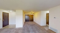 Located at 3330 E Kimberly Rd in Davenport, Iowa, this single-floor unit offers three bedrooms and two bathrooms across a comfortable and functional layout. The living room is a standout space, featuring plush carpeting, a textured ceiling, and a large sliding glass door with vertical blinds that invites generous natural light and outdoor views. The open layout connects seamlessly to a dedicated hallway leading to the kitchen and bedrooms. The kitchen is equipped with essential appliances, including a white refrigerator and an electric range, complemented by warm wood-toned cabinetry and a dedicated dining area. The spacious primary bedroom features a ceiling fan, a large double-door closet with rich wood paneling, and soft carpeting throughout. The additional bedrooms are well-sized, each with carpeted floors, neutral walls, and individual closets. Both bathrooms are practical and clean in design — one features a marble-patterned vanity countertop with a large mirror and overhead lighting, while the other includes a full tub-shower combination with tile flooring. Dark wood-trimmed interior doors are consistent throughout, lending a cohesive and classic aesthetic to the entire unit.