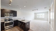 Located at 700 Darley Green Dr in Claymont, Delaware, this well-appointed one-bedroom, one-bathroom residence offers a thoughtfully designed single-floor layout with a clean, modern aesthetic throughout. Neutral-toned walls, white trim, and plush carpeting in the living and bedroom areas create a warm, cohesive feel.

The open-concept kitchen and living room is a standout feature, anchored by a granite-topped peninsula with an integrated sink — ideal for both casual dining and entertaining. Rich dark-espresso cabinetry provides ample storage, while stainless steel appliances, including a gas range, microwave, and refrigerator, complete the contemporary kitchen. Track lighting overhead enhances functionality and style. Hardwood-style flooring runs through the kitchen, transitioning seamlessly to carpet in the living area, which features a glass-paneled door leading to a private balcony with outdoor views.

The spacious bedroom is generously proportioned, benefiting from natural light through a large window and sliding glass door access to an outdoor space. A dedicated walk-in closet with built-in wire shelving provides practical storage. The bathroom is finished with large-format tile flooring, a dark-cabinetry vanity, a framed mirror, and clean white fixtures, delivering a polished, modern look.