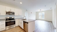 Located at 630 Chapel St in New Haven, CT, this well-appointed 2-bedroom, 2-bathroom residence offers a thoughtfully designed single-level floor plan with modern finishes throughout. Light-toned hardwood-style flooring flows seamlessly across the living spaces, creating a cohesive and welcoming ambiance.

The open-concept kitchen is a standout feature, outfitted with crisp white cabinetry, grey quartz countertops, a peninsula island with an undermount sink, and a full suite of stainless steel appliances including a refrigerator, range, microwave, and dishwasher — ideal for both everyday living and entertaining.

The primary bedroom offers a comfortable footprint with natural light and dedicated closet storage. The second bedroom features a sliding glass door opening to a private balcony with exterior views, while an additional bedroom benefits from a large window overlooking the surrounding neighborhood.

Both bathrooms are finished with wood-look porcelain tile flooring, white floating vanities with grey countertops, and matte black fixtures. One bathroom includes a tub-shower combination, while the other offers a walk-in shower. Two closets and a hallway complete the layout, providing ample storage. The unit's clean, neutral palette and contemporary design make it a versatile and modern living space.