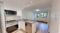 Located at 535–555 Shaw Ave in Coquitlam, BC, this well-designed one-bedroom, one-bathroom unit offers a thoughtfully organized single-floor layout with a clean, contemporary aesthetic. The open-concept kitchen is a standout feature, showcasing white shaker-style cabinetry extending to the ceiling, a classic subway tile backsplash, dark quartz countertops, and a peninsula with an undermount sink. Stainless steel appliances — including a full-size refrigerator, built-in microwave, and dishwasher — complete the modern kitchen ensemble. Light wood-look vinyl flooring flows seamlessly from the kitchen into the living area, which benefits from natural light through black-framed windows with views of greenery outside. The bedroom is a comfortable, bright space with crisp white walls, the same warm flooring, a mirrored sliding-door closet, and baseboard heating. The bathroom is finished in a clean, accessible style with large-format tile flooring, white subway tile surround, a quartz-topped vanity with white cabinetry, a large mirror, and chrome grab bars for added safety. Throughout the unit, white walls, recessed and flush-mount lighting, and consistent flooring choices create a cohesive, modern, and inviting atmosphere.