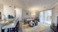 Located at 1700 Charleston Place Ln in Charlotte, NC, this single-story residence offers a thoughtfully designed layout with a comfortable flow throughout. The living room serves as the heart of the home, featuring crown molding, wood-style flooring, a tile-surround fireplace, and sliding glass doors that open to a private outdoor patio, allowing generous natural light to fill the space. The kitchen is outfitted with white cabinetry, granite countertops, a subway tile backsplash, and black appliances, including a range, over-the-range microwave, and refrigerator. Adjacent to the kitchen, the dining area accommodates a full-sized dining table and benefits from a window overlooking the outdoors. Two well-proportioned bedrooms feature plush carpeting, neutral tones, and windows with natural light. One bedroom includes an ensuite bathroom, while both bathrooms are finished with granite-topped white vanities, wood-style flooring, and tub/shower combinations. Crown molding is a recurring design detail throughout the main living areas, contributing to a polished and cohesive interior aesthetic.