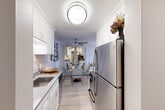Located at 1212 Whipple Ave in Redwood City, California, this well-appointed one-bedroom, one-bathroom residence offers a thoughtfully designed single-level layout. Crown molding runs throughout, lending a clean, polished finish to each room.

The galley-style kitchen is efficiently organized, featuring white shaker cabinetry extending to the ceiling for ample storage, stainless steel appliances including a refrigerator and range, a deep sink with a modern faucet, and a neutral tile backsplash. Light wood-style flooring carries through the kitchen and into the adjacent living and dining areas.

The living room is bright and inviting, benefiting from a large window that brings in natural light and offers a view of the surrounding greenery. Crown molding and a ceiling fan add to the room's comfortable, finished character.

The bedroom is carpeted for warmth and comfort, featuring a built-in mirrored sliding-door closet with shelving, a window with outdoor views, and crown molding consistent with the rest of the home.

The bathroom is clean and functional, with a full soaking tub and shower combination set against marble-patterned surround walls and light wood-style flooring.

A connecting hallway ties the rooms together, creating a cohesive and practical flow throughout the residence.